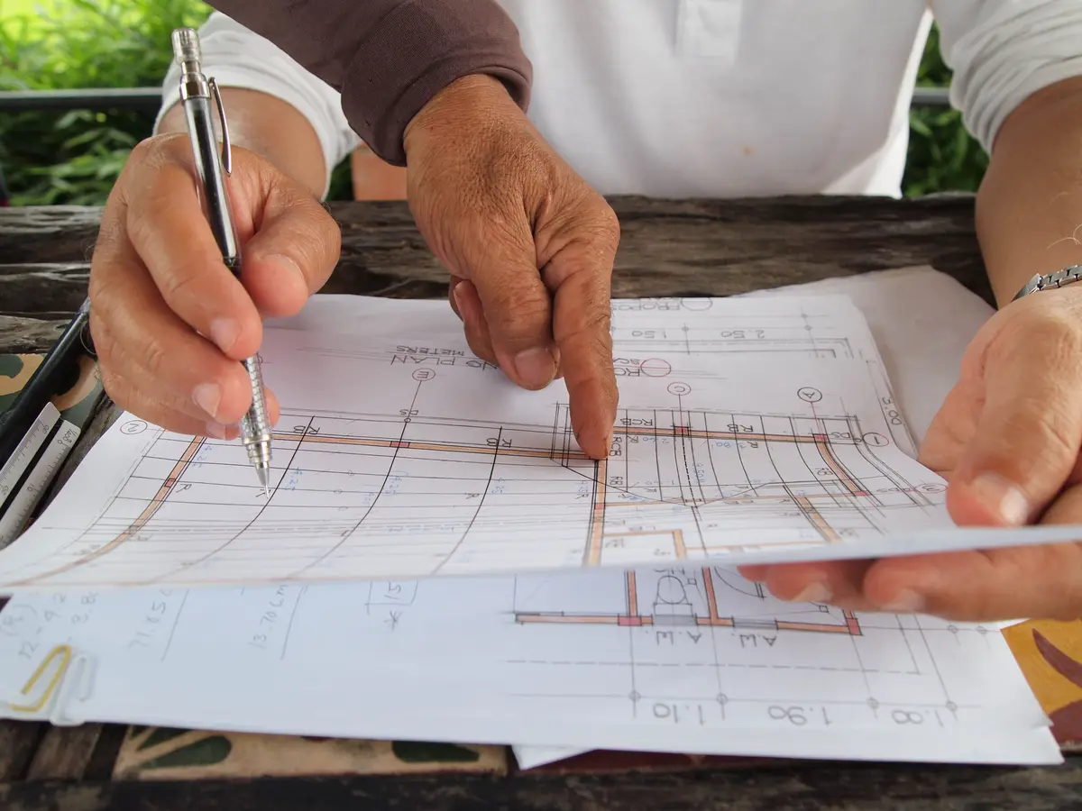 Hands marking up a set of house plans