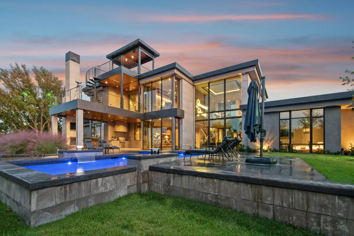 A modern luxury home at dusk with its lights on