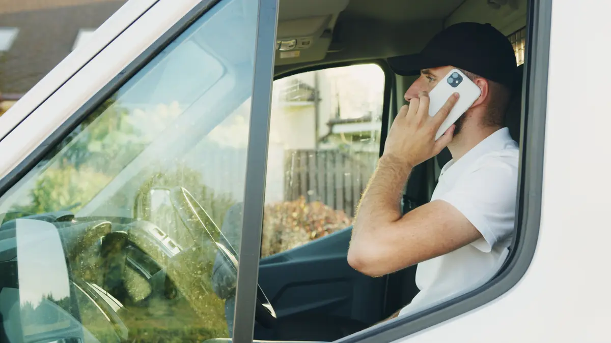 A contractor taking a call in his work van